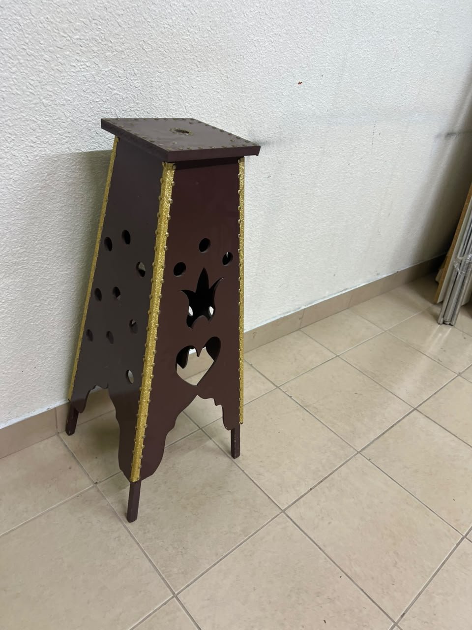 A tall wooden garment incense burner (incense stand) featuring a tower or pyramid design; it is used to scent abayas, clothing, and fabrics by hanging or placing them over the burner, allowing them to absorb the fragrance of incense and oud.