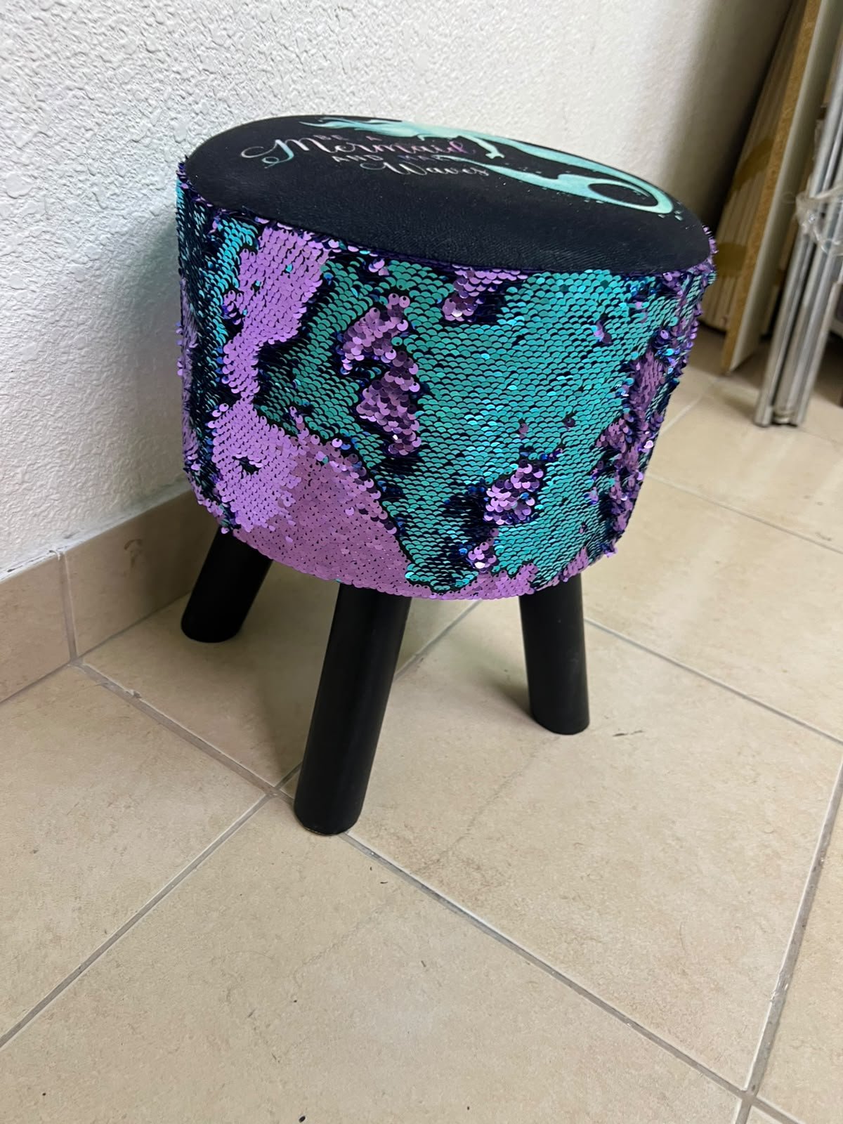 This product is a small decorative stool featuring a "mermaid" sequin design—with reversible sequins that change color—and sturdy black wooden legs. - Image 2