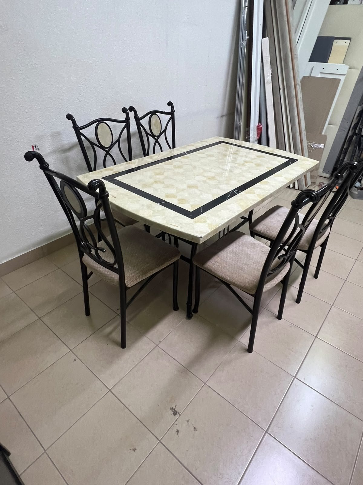 A dining table featuring a metal design with a decorative top and a set of matching upholstered chairs; it appears suitable for home use or a functional office setting. - Image 2