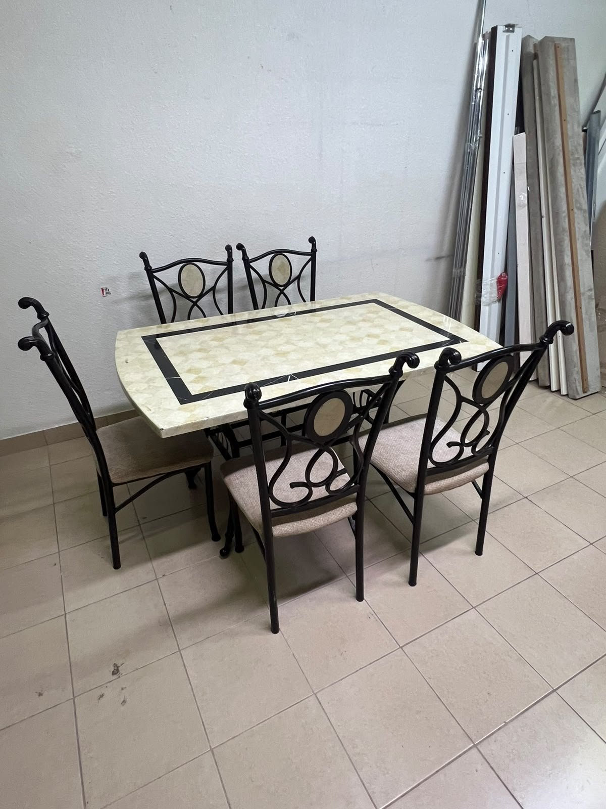 A dining table featuring a metal design with a decorative top and a set of matching upholstered chairs; it appears suitable for home use or a functional office setting. - Image 4