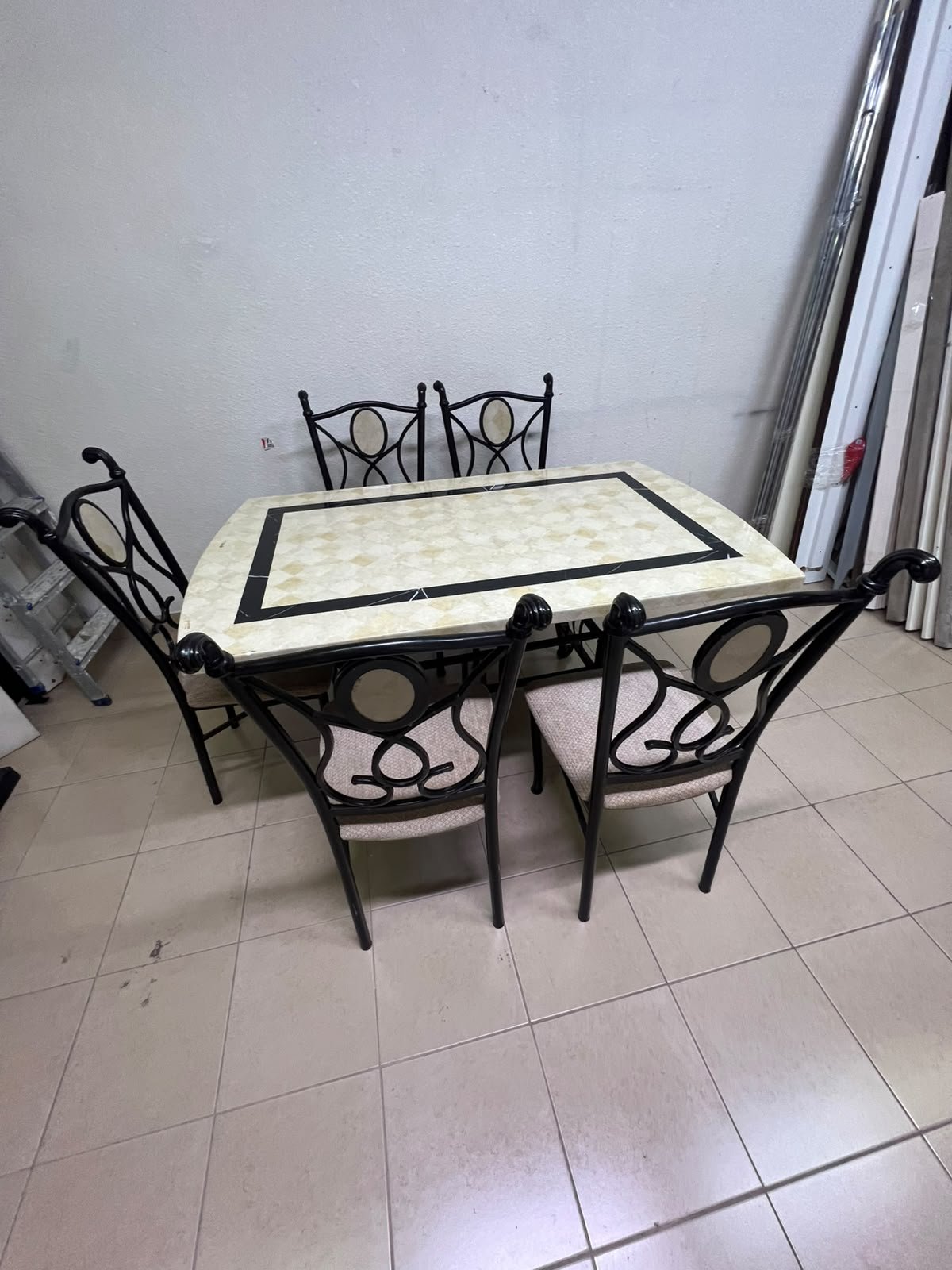 A dining table featuring a metal design with a decorative top and a set of matching upholstered chairs; it appears suitable for home use or a functional office setting. - Image 6