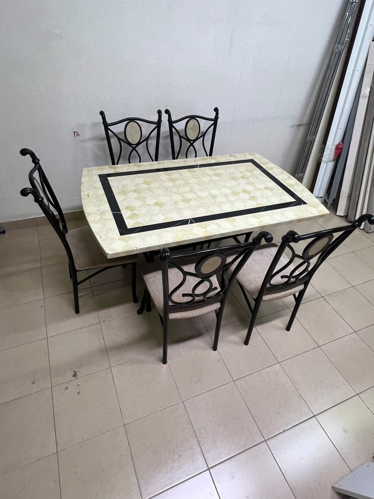 A dining table featuring a metal design with a decorative top and a set of matching upholstered chairs; it appears suitable for home use or a functional office setting. - Image 11