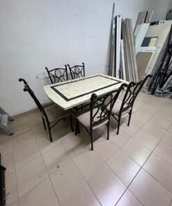 A dining table featuring a metal design with a decorative top and a set of matching upholstered chairs; it appears suitable for home use or a functional office setting. - Image 12