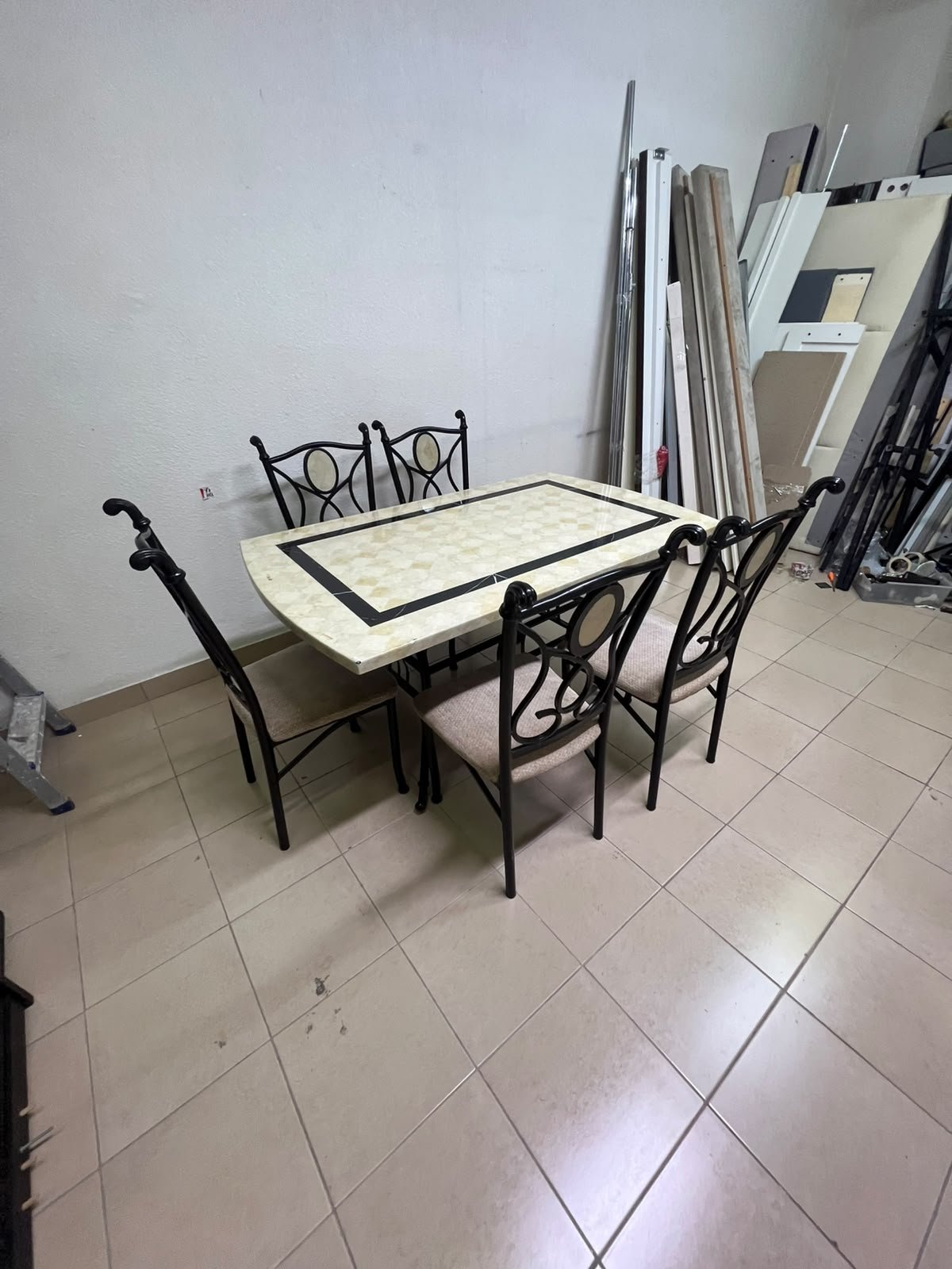 A dining table featuring a metal design with a decorative top and a set of matching upholstered chairs; it appears suitable for home use or a functional office setting. - Image 12