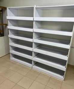 Commercial display shelving units—or slanted racks for organizing shoes or products—made of wood or white MDF. Each unit features several horizontal or slightly inclined shelves equipped with front edges to prevent products from falling. - Image 3
