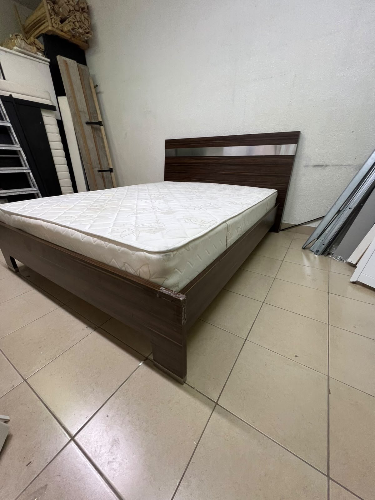 A dark brown wooden double bed featuring a headboard accented with a silver metal strip, and equipped with a white padded mattress. - Image 4