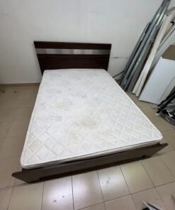A dark brown wooden double bed featuring a headboard accented with a silver metal strip, and equipped with a white padded mattress. - Image 9