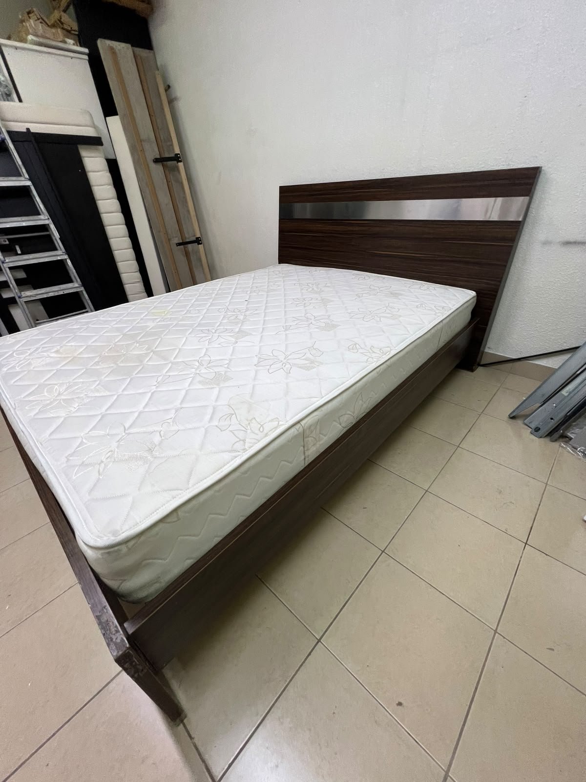 A dark brown wooden double bed featuring a headboard accented with a silver metal strip, and equipped with a white padded mattress. - Image 11