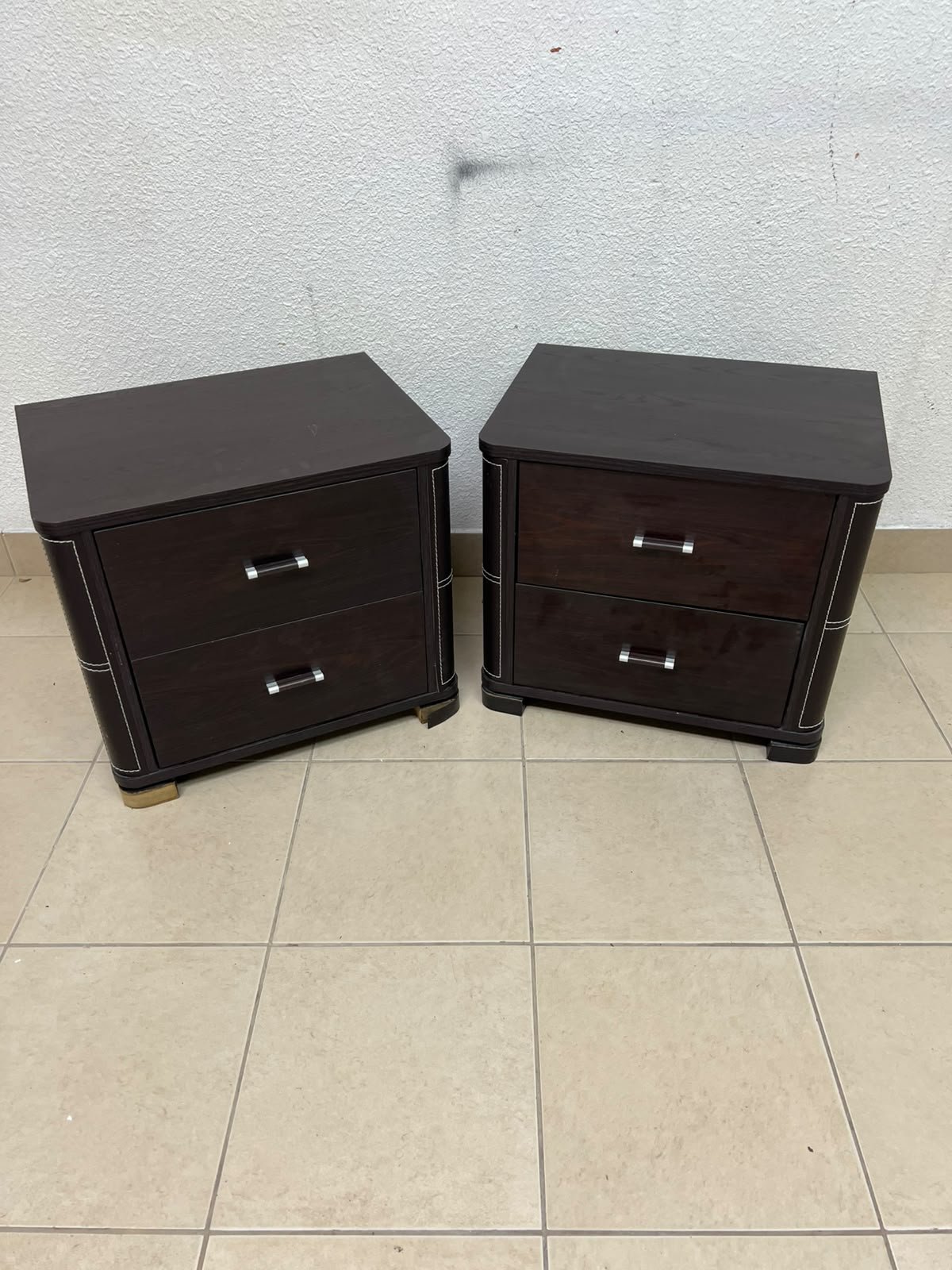 Two dark brown wooden bedside tables (nightstands) featuring two drawers and curved corners, accented with contrasting white stitching and silver-colored metal drawer handles. - Image 5