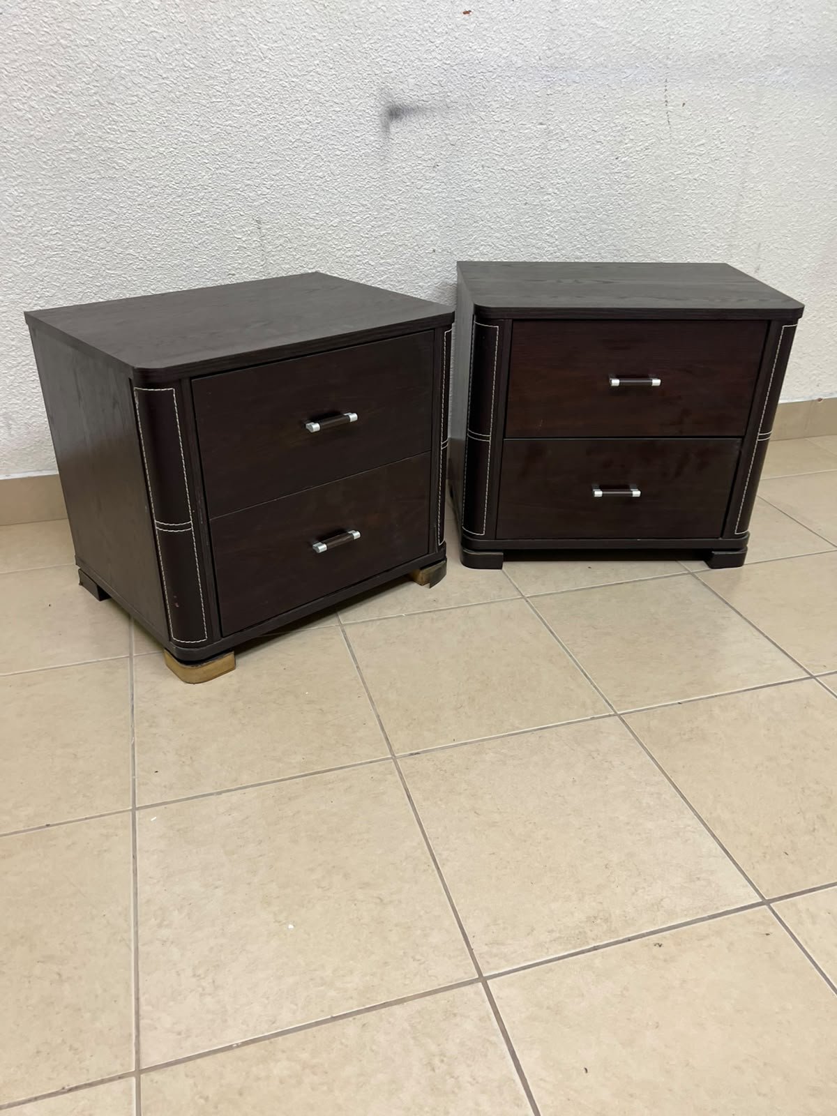 Two dark brown wooden bedside tables (nightstands) featuring two drawers and curved corners, accented with contrasting white stitching and silver-colored metal drawer handles. - Image 6