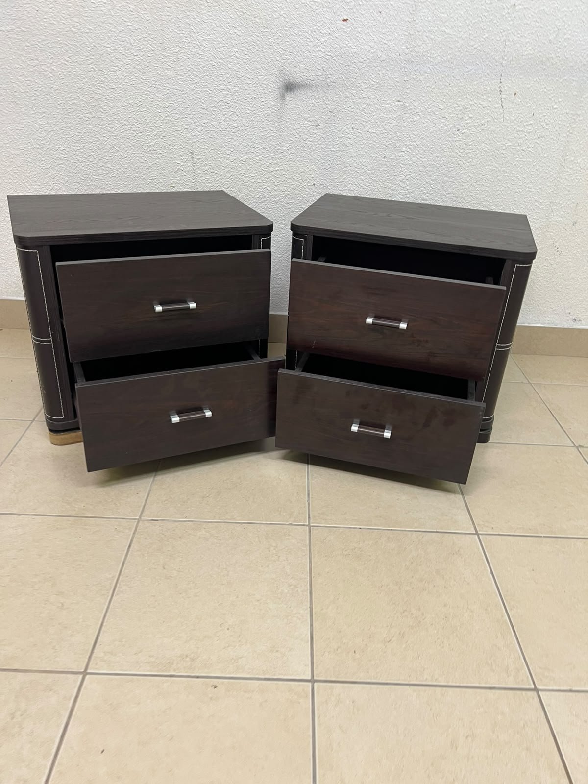 Two dark brown wooden bedside tables (nightstands) featuring two drawers and curved corners, accented with contrasting white stitching and silver-colored metal drawer handles. - Image 7