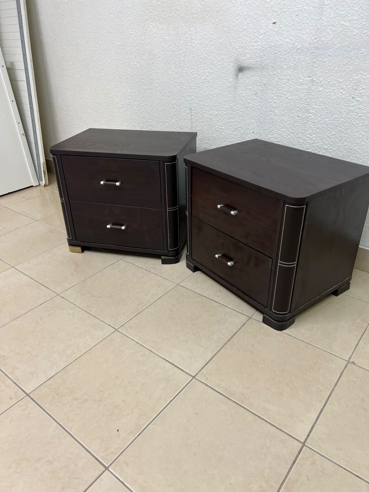Two dark brown wooden bedside tables (nightstands) featuring two drawers and curved corners, accented with contrasting white stitching and silver-colored metal drawer handles. - Image 10