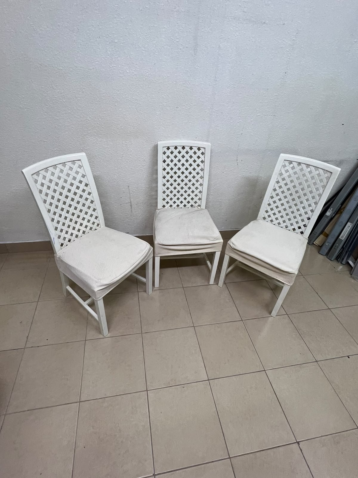 A set of white wooden chairs featuring a woven-mesh backrest design and white seat covers. - Image 2