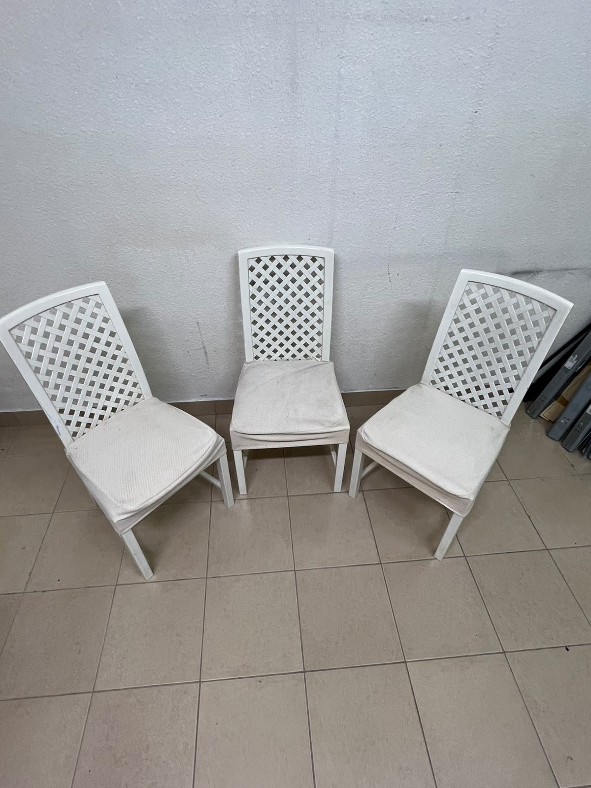 A set of white wooden chairs featuring a woven-mesh backrest design and white seat covers. - Image 3