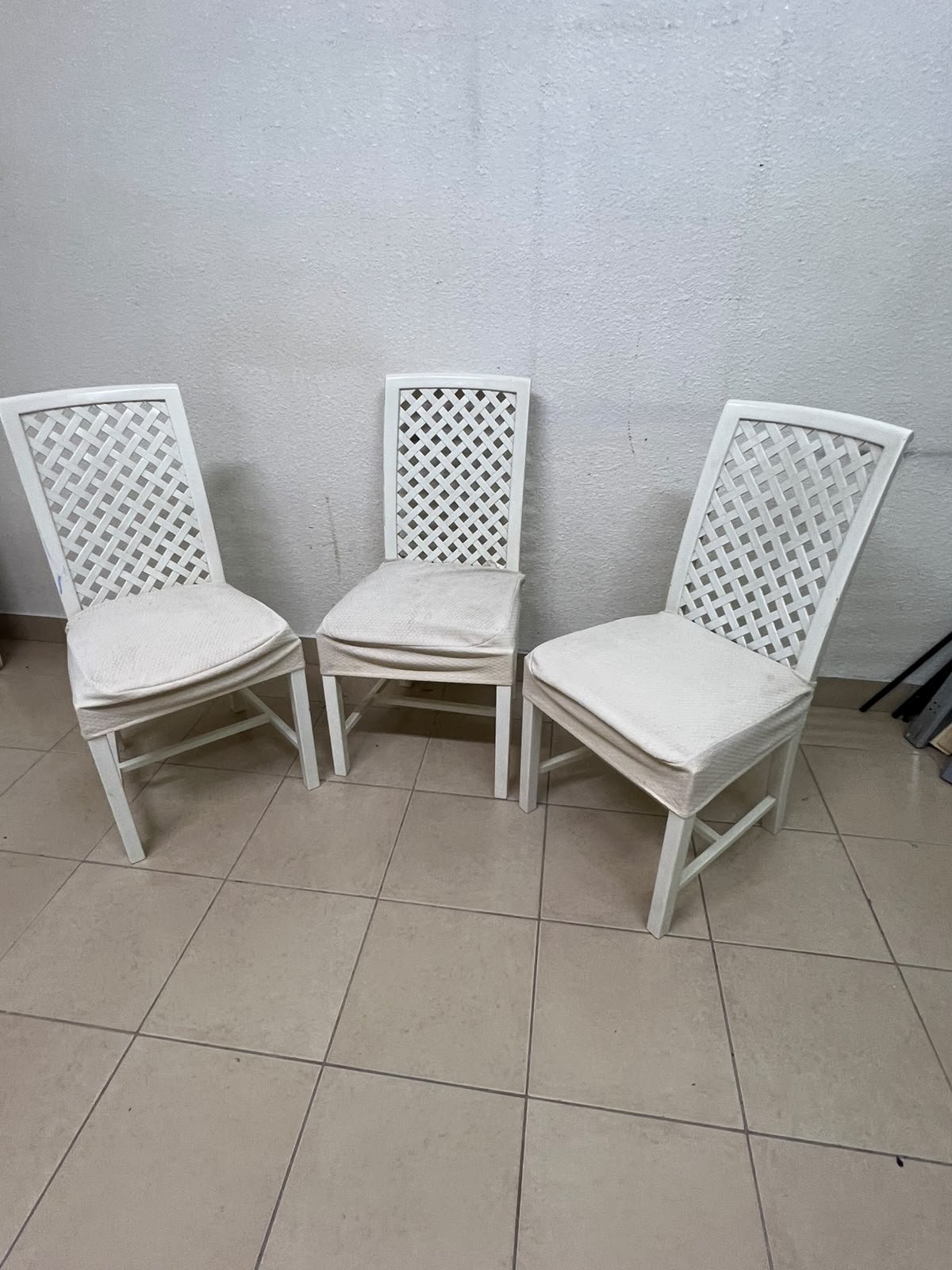 A set of white wooden chairs featuring a woven-mesh backrest design and white seat covers. - Image 6