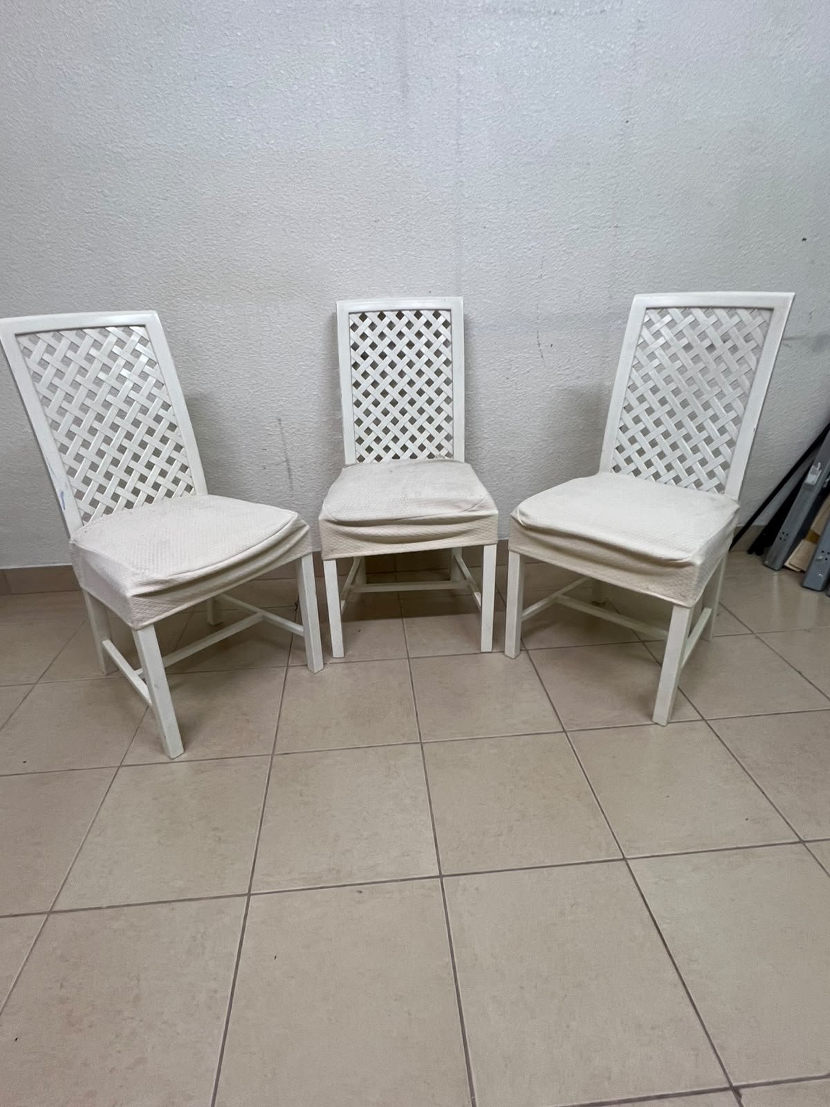 A set of white wooden chairs featuring a woven-mesh backrest design and white seat covers. - Image 7