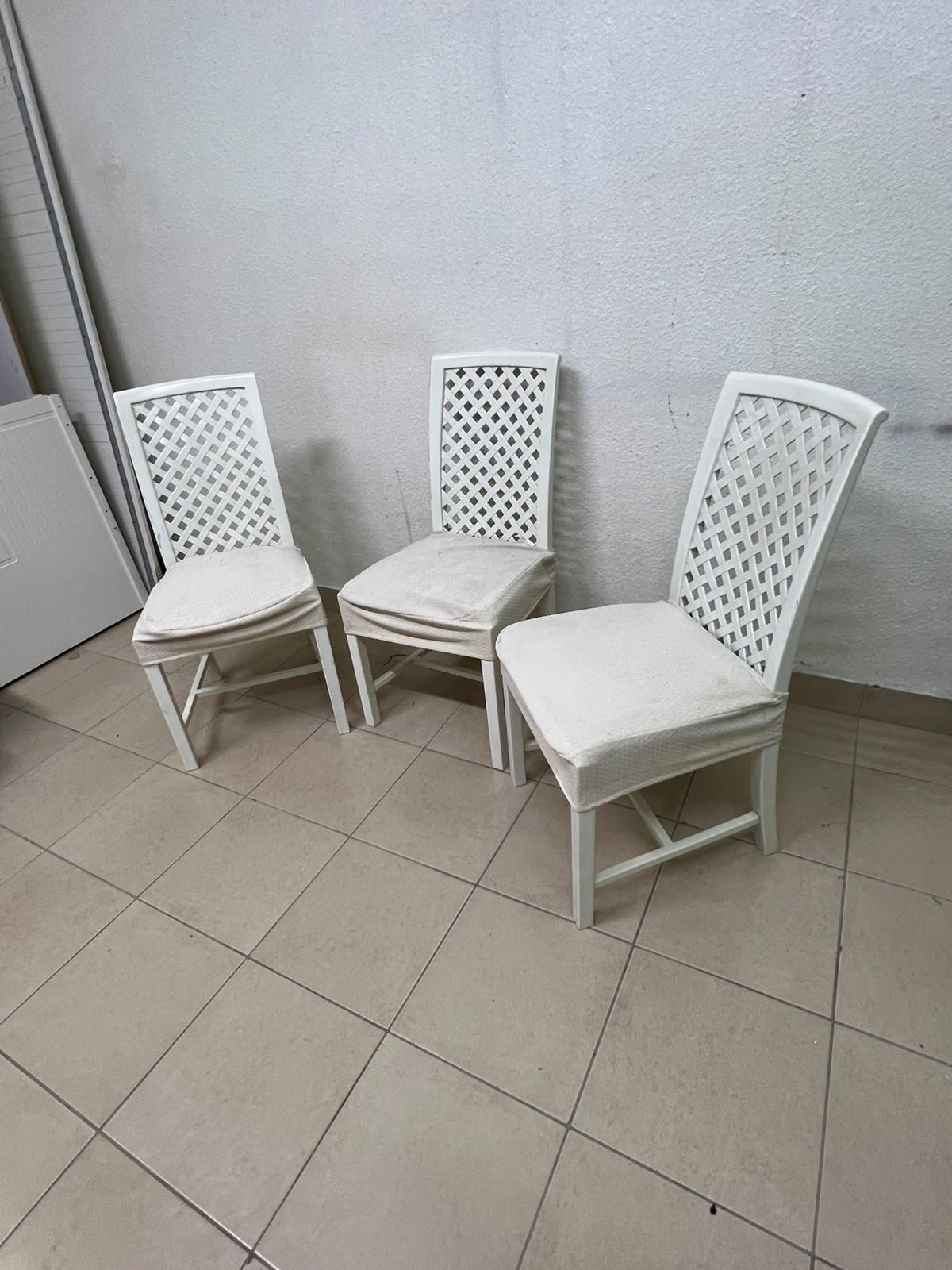 A set of white wooden chairs featuring a woven-mesh backrest design and white seat covers. - Image 8