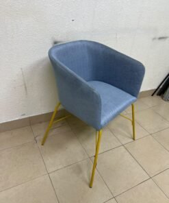A modern barrel-style armchair or upholstered dining chair, featuring light blue fabric upholstery and slender yellow metal legs. - Image 2