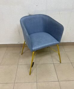 A modern barrel-style armchair or upholstered dining chair, featuring light blue fabric upholstery and slender yellow metal legs.