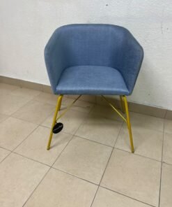 A modern barrel-style armchair or upholstered dining chair, featuring light blue fabric upholstery and slender yellow metal legs. - Image 6