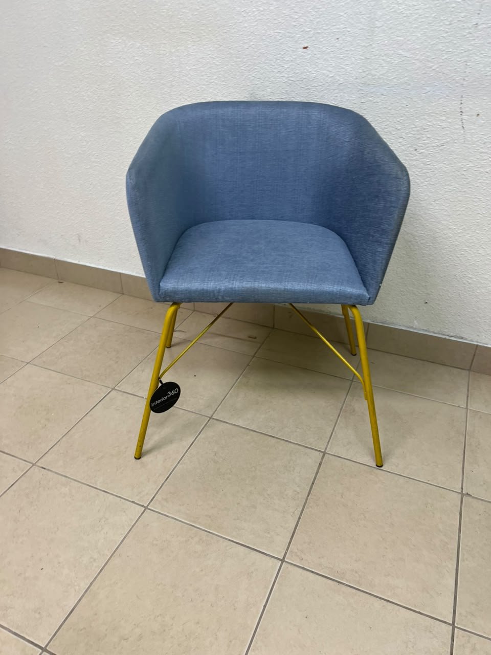 A modern barrel-style armchair or upholstered dining chair, featuring light blue fabric upholstery and slender yellow metal legs. - Image 6