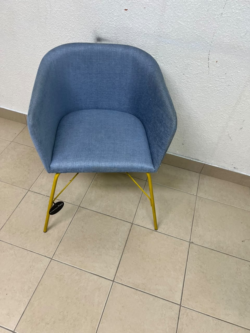 A modern barrel-style armchair or upholstered dining chair, featuring light blue fabric upholstery and slender yellow metal legs. - Image 7
