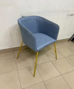 A modern barrel-style armchair or upholstered dining chair, featuring light blue fabric upholstery and slender yellow metal legs. - Image 8