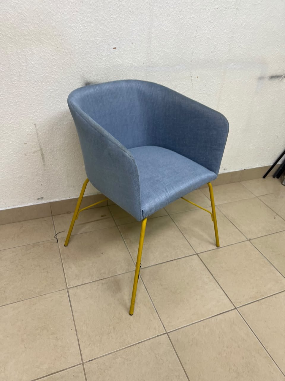 A modern barrel-style armchair or upholstered dining chair, featuring light blue fabric upholstery and slender yellow metal legs. - Image 8
