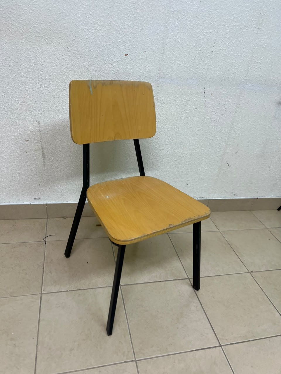 Classic school chair featuring a plywood seat and backrest, and a black metal frame.