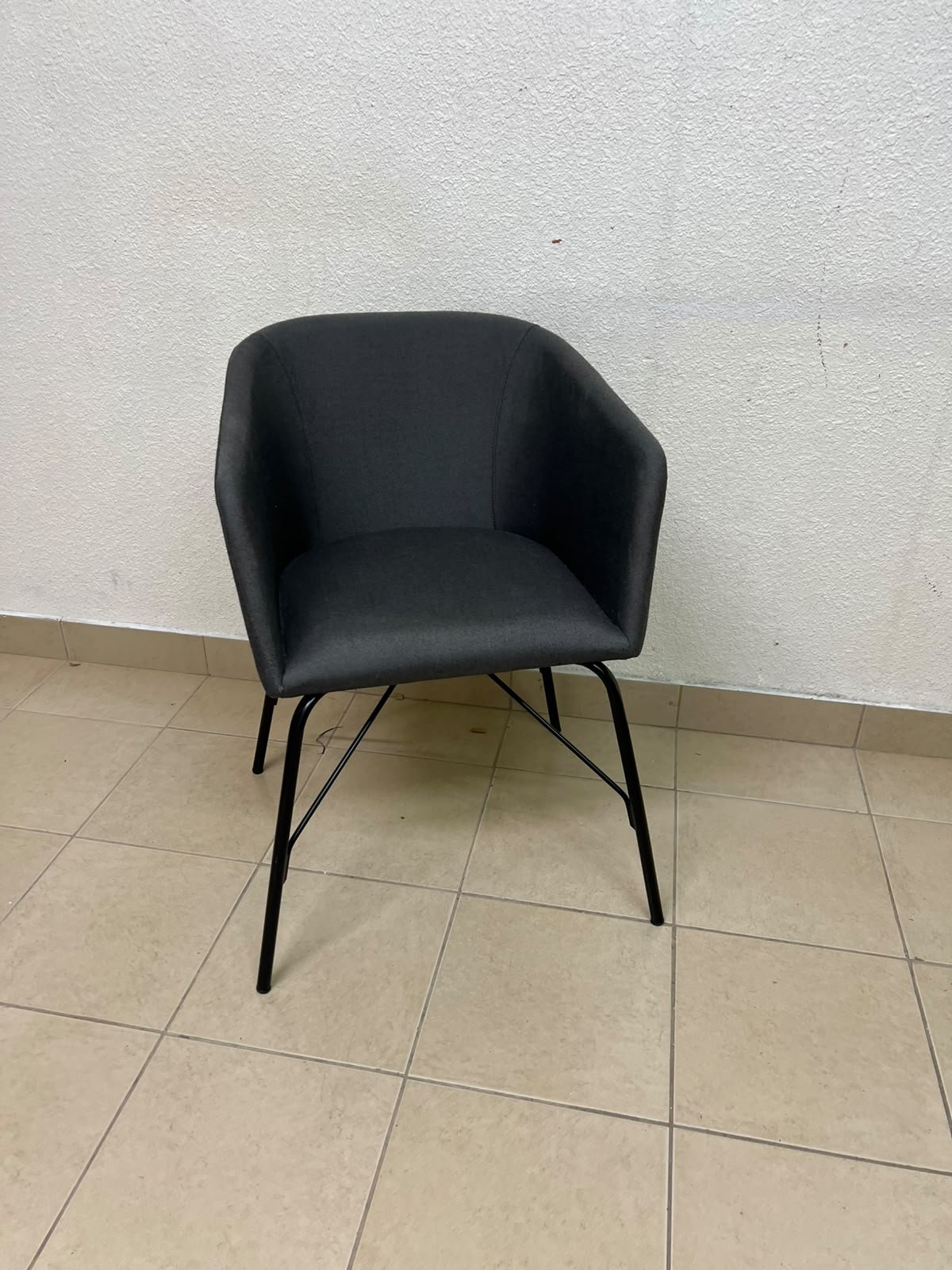 The chair shown in the picture looks similar to the TOSSBERG model from IKEA, made of dark gray fabric with black metal legs. - Image 7
