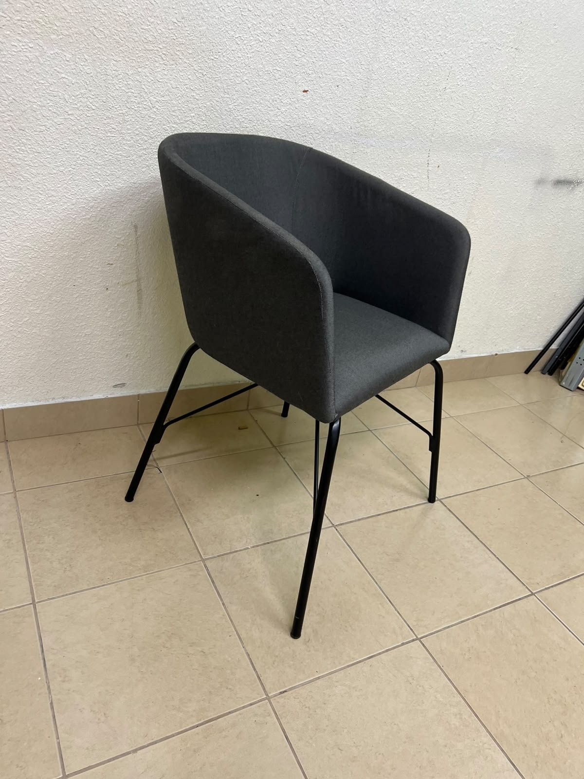 The chair shown in the picture looks similar to the TOSSBERG model from IKEA, made of dark gray fabric with black metal legs. - Image 2