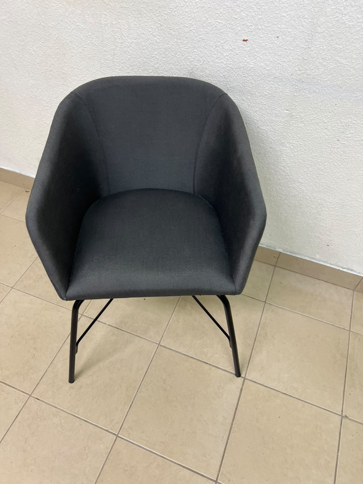 The chair shown in the picture looks similar to the TOSSBERG model from IKEA, made of dark gray fabric with black metal legs. - Image 4