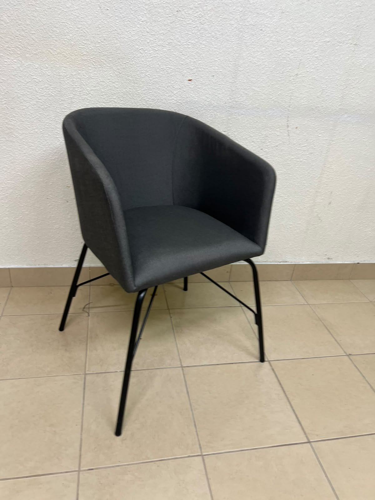 The chair shown in the picture looks similar to the TOSSBERG model from IKEA, made of dark gray fabric with black metal legs.