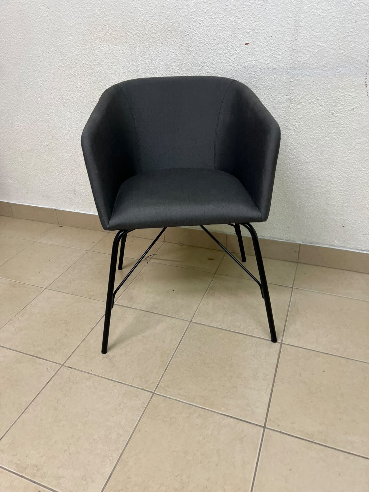 The chair shown in the picture looks similar to the TOSSBERG model from IKEA, made of dark gray fabric with black metal legs. - Image 5
