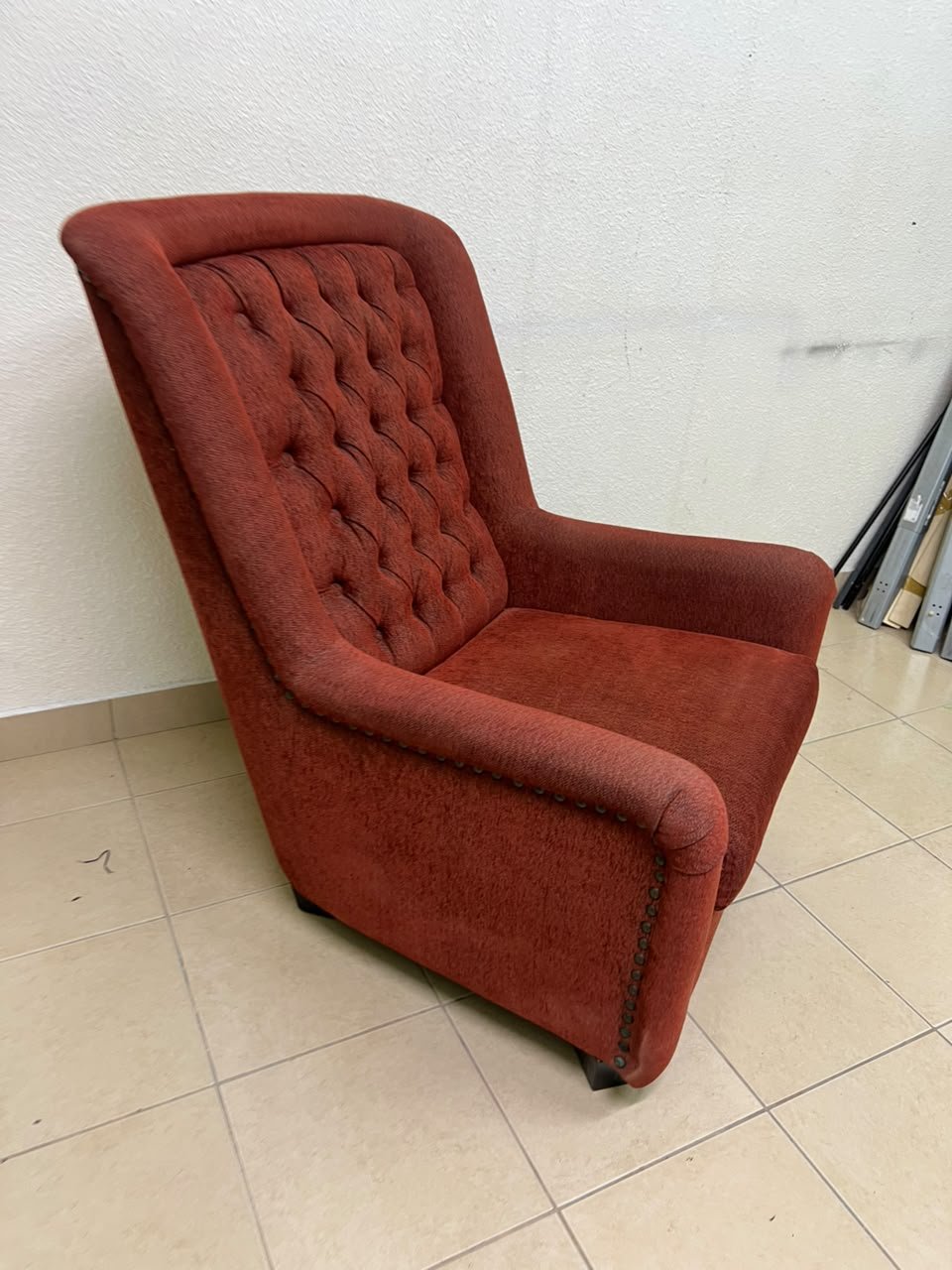 A classic-style armchair featuring a high, button-tufted backrest, upholstered in textured dark red fabric, and accented with metal nailhead trim along the edges. - Image 4