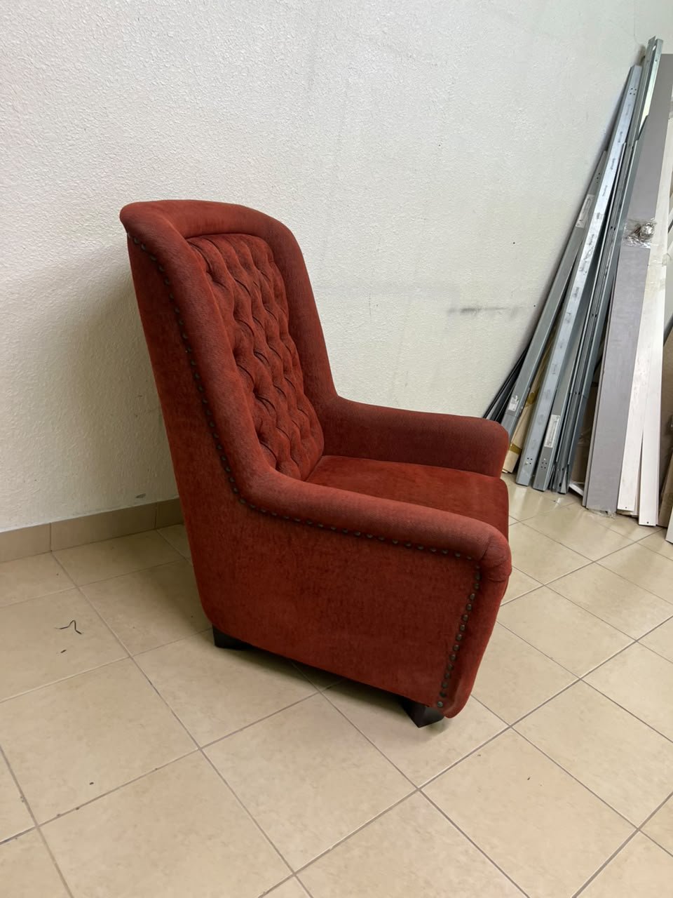 A classic-style armchair featuring a high, button-tufted backrest, upholstered in textured dark red fabric, and accented with metal nailhead trim along the edges. - Image 9