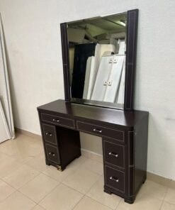 The image shows a brown wooden vanity table with an attached mirror and multiple drawers.