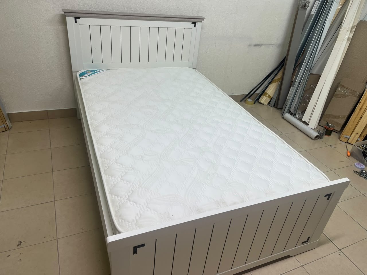 A white wooden single bed featuring a pull-out trundle bed underneath, with two matching padded mattresses. - Image 2