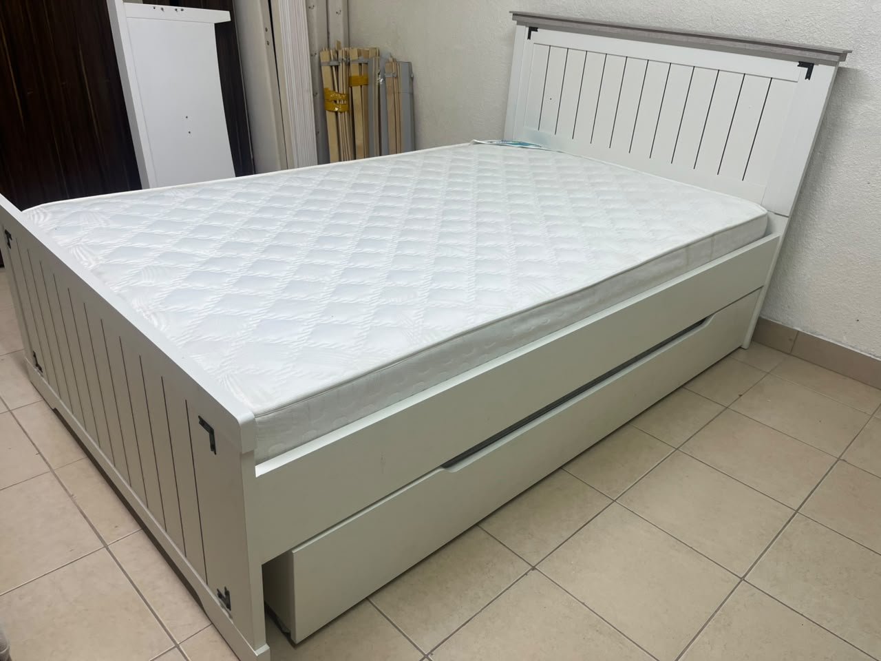 A white wooden single bed featuring a pull-out trundle bed underneath, with two matching padded mattresses. - Image 7