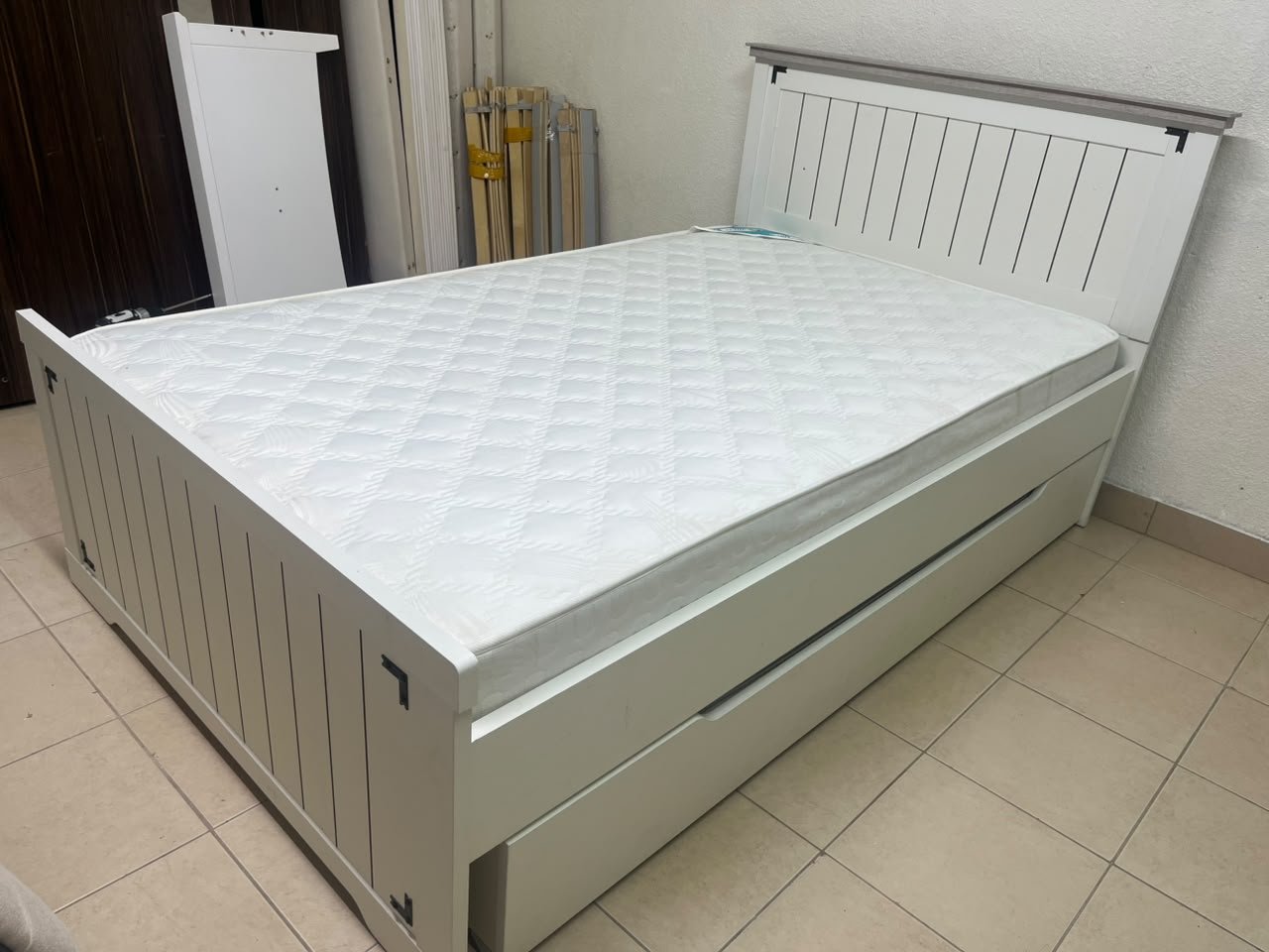 A white wooden single bed featuring a pull-out trundle bed underneath, with two matching padded mattresses. - Image 8