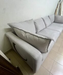 A modern sectional sofa upholstered in light gray fabric, featuring wide armrests with striking rounded details and matching, separate back cushions. - Image 2