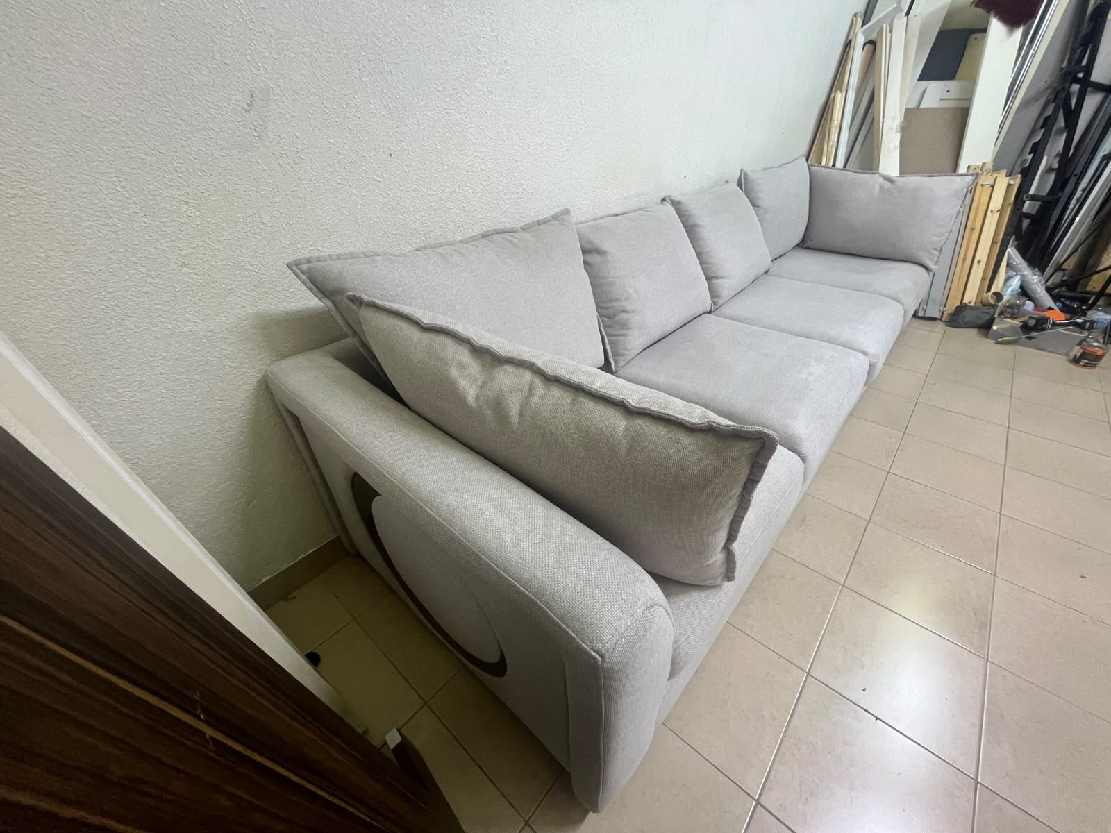 A modern sectional sofa upholstered in light gray fabric, featuring wide armrests with striking rounded details and matching, separate back cushions. - Image 2
