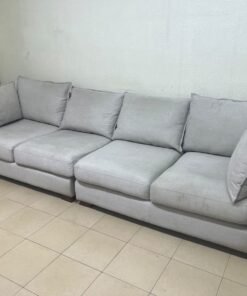 A modern sectional sofa upholstered in light gray fabric, featuring wide armrests with striking rounded details and matching, separate back cushions. - Image 4