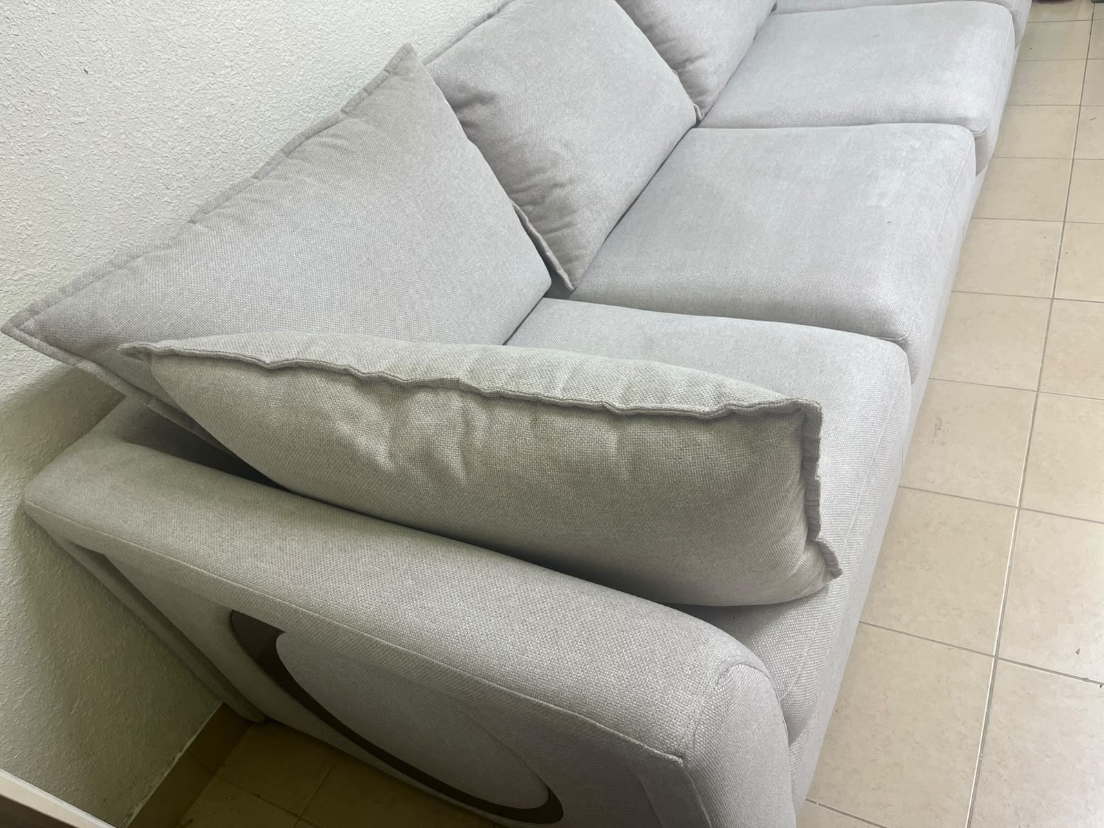A modern sectional sofa upholstered in light gray fabric, featuring wide armrests with striking rounded details and matching, separate back cushions. - Image 5