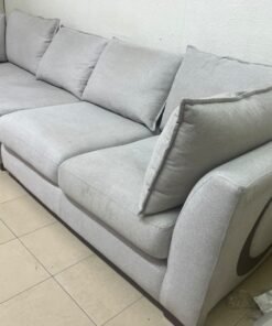 A modern sectional sofa upholstered in light gray fabric, featuring wide armrests with striking rounded details and matching, separate back cushions. - Image 6