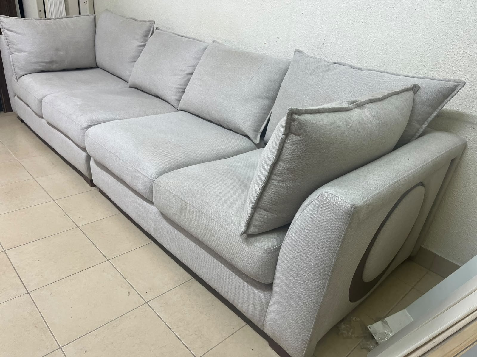 A modern sectional sofa upholstered in light gray fabric, featuring wide armrests with striking rounded details and matching, separate back cushions. - Image 6