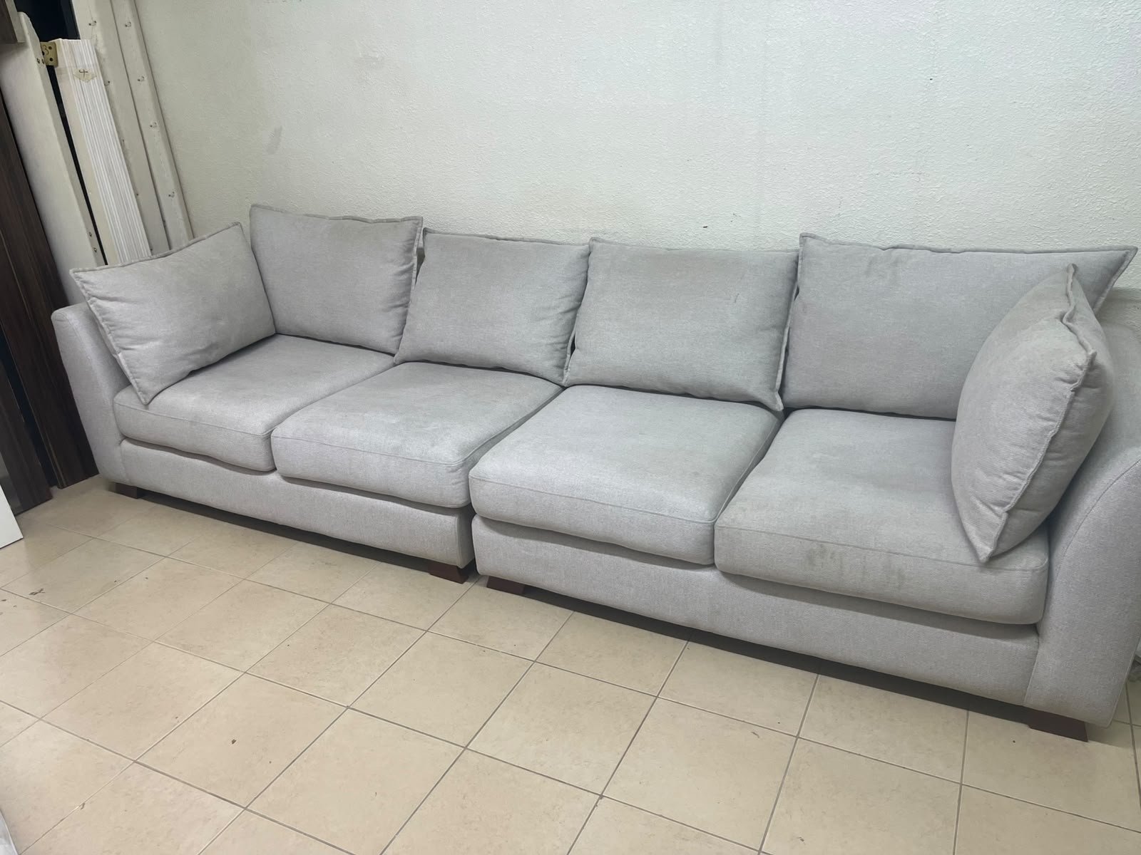 A modern sectional sofa upholstered in light gray fabric, featuring wide armrests with striking rounded details and matching, separate back cushions. - Image 7
