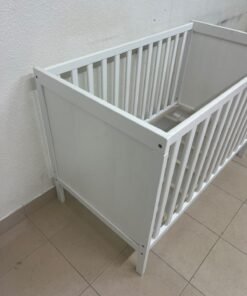 The white IKEA SUNDVIK crib (60x120 cm) features a sturdy wooden design and a bed base that can be adjusted to two different heights. - Image 6