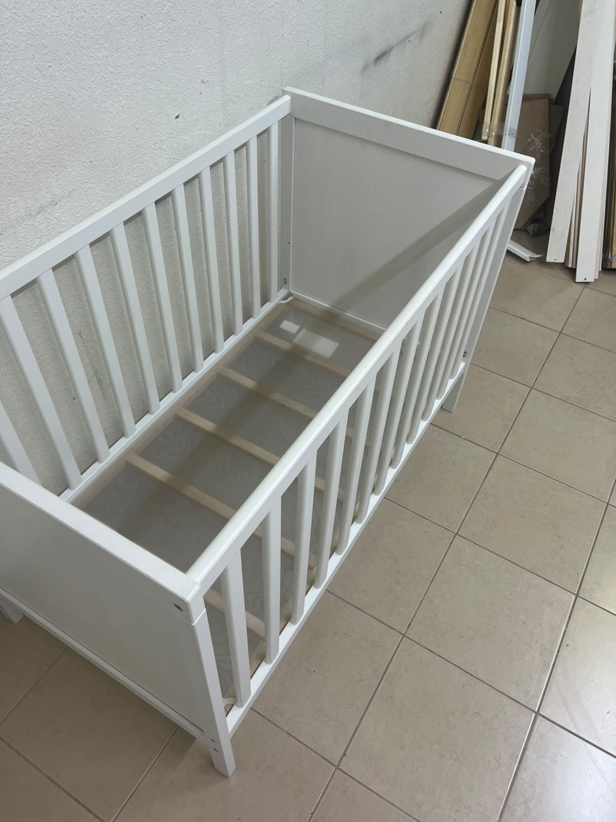 The white IKEA SUNDVIK crib (60x120 cm) features a sturdy wooden design and a bed base that can be adjusted to two different heights. - Image 9