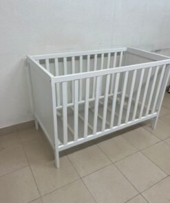 The white IKEA SUNDVIK crib (60x120 cm) features a sturdy wooden design and a bed base that can be adjusted to two different heights. - Image 11